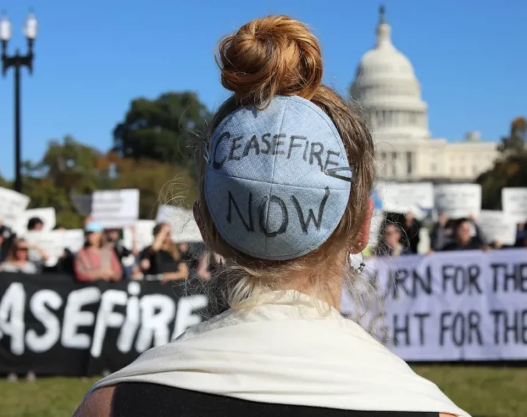 Μία γυναίκα φορά το εβραϊκό kippah το οποίο γράφει «Κατάπαυση πυρός τώρα», κατά τη διάρκεια διαδηλώσεων εβραϊκών οργανώσεων κατά της γενοκτονίας στη Γάζα, μπροστά στον Λευκό Οίκο.