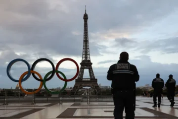 Αστυνομικοί μπροστά στον Πύργο του Άιφελ και τους πέντε κύκλους των Ολυμπιακών Αγώνων.